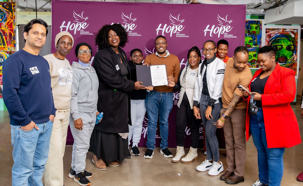 Hope for Refugees International members and volunteers receive the certificate of Safe Space Designation from the Rainbow Community of Canada.